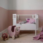 Sebra poppenwagen van hout wit in kinderkamer met ander speelgoed