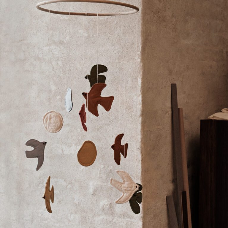 Ferm Living babymobiel met gekleurde vogels styling in de babykamer